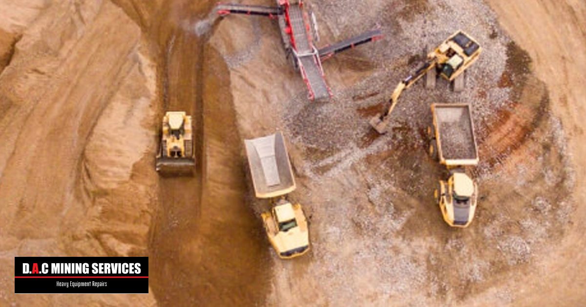 Birds eye view of heavy equipment vehicles working in a mining site - D.A.C Mining Services